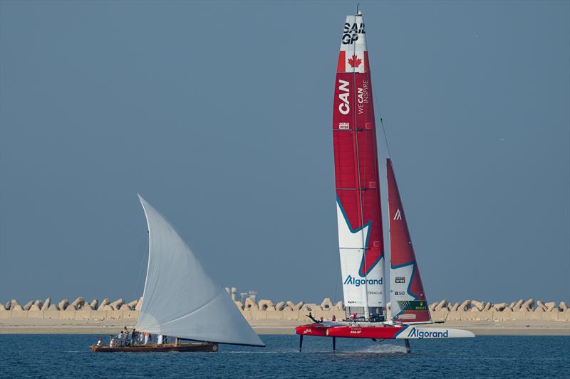 Canada SailGP Team helmed by Phil Robertson sail past a sailing dhow during a demonstration event ahead of the Dubai Sail Grand Prix presented by P&O Marinas in Dubai, United Arab Emirates photo copyright Bob Martin for SailGP taken at  and featuring the Dhow class