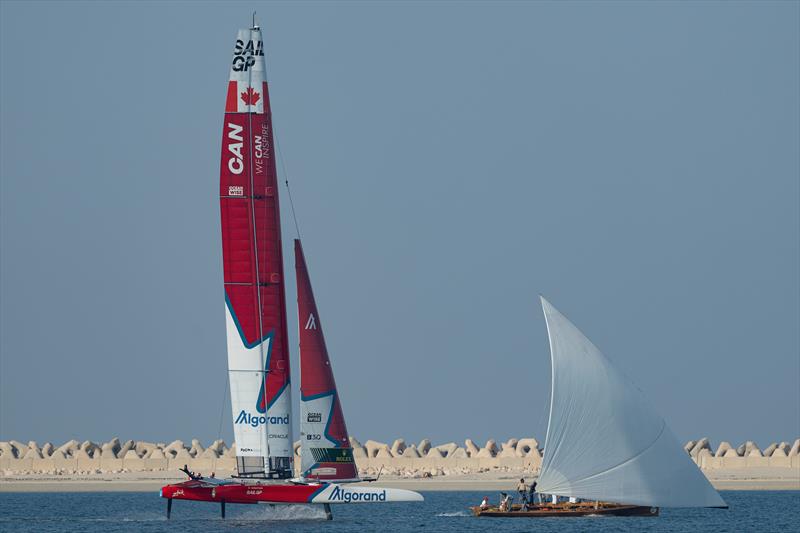 Canada SailGP Team helmed by Phil Robertson sail past a sailing dhow during a demonstration event ahead of the Dubai Sail Grand Prix presented by P&O Marinas in Dubai, United Arab Emirates photo copyright Bob Martin for SailGP taken at  and featuring the Dhow class