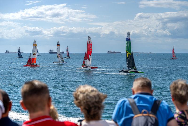 Spectators watch on from the seawall as Australia SailGP Team helmed by Tom Slingsby lead the fleet close by on Race Day 2 of the ROCKWOOL Italy Sail Grand Prix in Taranto, Italy - photo © Andrew Baker for SailGP