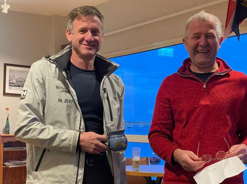 Noel Butler (L) picks up his Frostbite Mug for the first race of the Series from Neil Colin (Noel is a stalwart of the Frostbites, saying this may be his 29th consecutive series) photo copyright Sarah Dwyer taken at Dun Laoghaire Motor Yacht Club and featuring the Fireball class