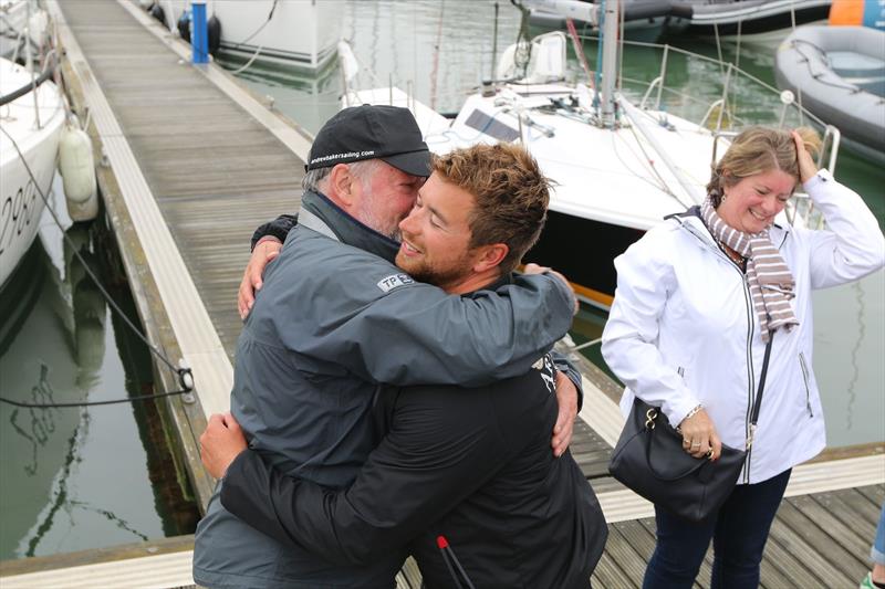 Andrew Baker greets his father Brian on the pontoon as the La Solitaire Bompard Le Figaro fleet arrives in Cowes photo copyright Artemis Offshore Academy taken at  and featuring the Figaro class