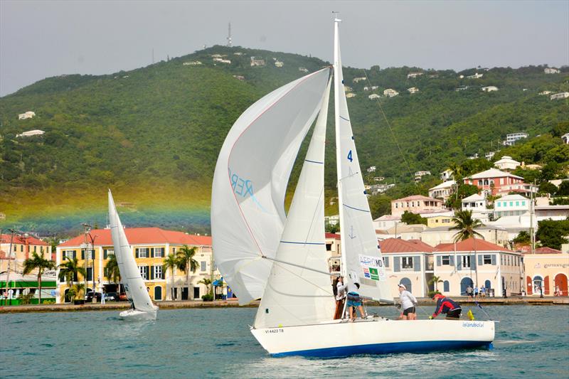 Dave Dellenbaugh after a squall with the backdrop of a rainbow over the town of Charlotte during the 2015 Carlos Aguilar Match Race photo copyright Dean Barnes taken at St. Thomas Yacht Club and featuring the Match Racing class