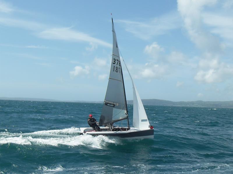 David Winder crossing the finish line at the Pwllheli open meeting photo copyright Ian Mackenzie taken at Pwllheli Sailing Club and featuring the Merlin Rocket class