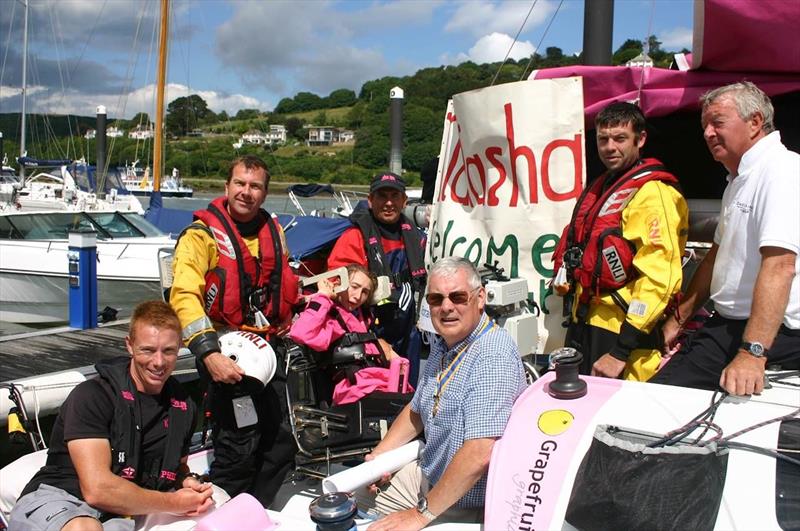 Peter Goldstraw from The Rotary Club of Dartmouth (centre) prepares to present Natasha with a cheque as she is welcomed to Dartmouth by the RNLI Dart Lifeboat and Dart Sailability, Dad Gary and coach Phil Devereux watch on - photo © Anne Bailey / Dart Sailability