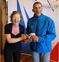 Bretzel Bakery MD Dymphna O'Brien presents Marco Sorgassi (RStGYC) with the “Mug of the Day” prize for his spectacular “missed the toestrap” capsize!, Irish RS Aero Nationals 2023 © Stephen Oram