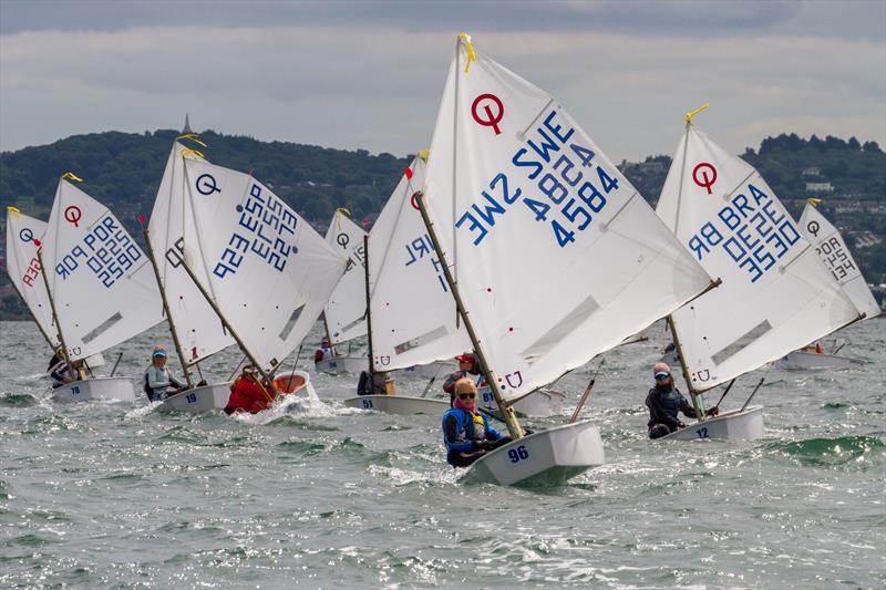 Swedish sailor Josefine Ãâkesson (SWE 4584) leading a mixed international fleet on the second day of the Optimist European Championships on Dublin Bay photo copyright Gareth Craig / www.fotosail.com taken at Royal St George Yacht Club and featuring the Optimist class