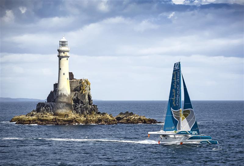 Oman Air Musadam (OMA) rounds the Fastnet Rock in the Rolex Fastnet Race 2013 photo copyright Kurt Arrigo / Rolex taken at  and featuring the Trimaran class
