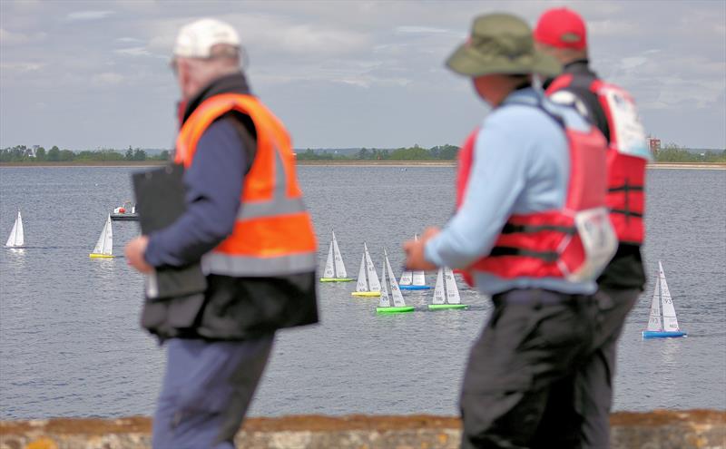 2026 IOM Worlds at Datchet Water Day 4 - Skippers walk the wall watching their yachts photo copyright Mark Jardine taken at Datchet Water Sailing Club and featuring the One Metre class