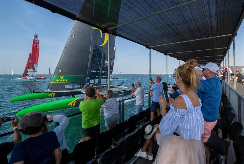 Spectators watch the Australia SailGP Team sail closely past the Waterfront Platinum Area on Race Day 1 of the Dubai Sail Grand Prix - November 12, 2022 photo copyright Adam Warner/SailGP taken at Dubai Offshore Sailing Club and featuring the AC50 class