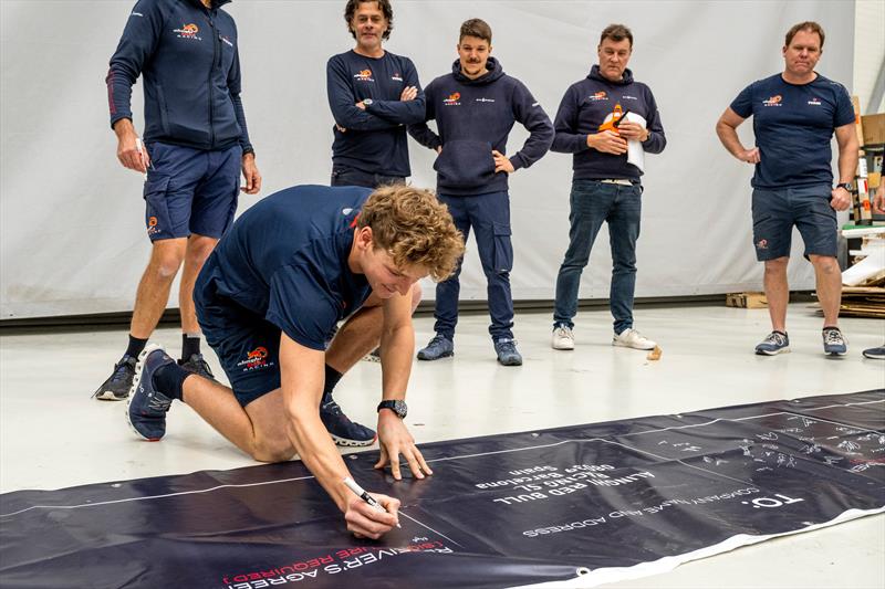 Team members sign shipment card of AC75 Boat One as she arrives at Alinghi Red Bull Racing base in Barcelona, Spain - March 4, 2024 photo copyright Olaf Pignataro/Red Bull Content Pool taken at Société Nautique de Genève and featuring the AC75 class