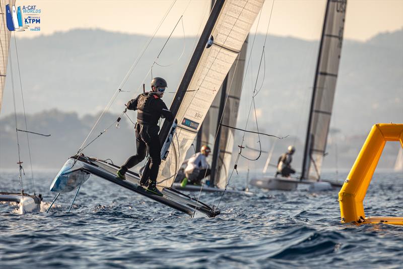 A-Cat Worlds at Toulon, France Day 1 - Swiss Champ, Robin Maeder SUI 007, rounds the top mark in unusual style trying extreme drag reduction techniques in the Open fleet. The race was cancelled photo copyright Gordon Upton / www.guppypix.com taken at Yacht Club de Toulon and featuring the A Class Catamaran class