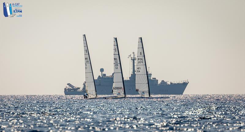 A-Cat Worlds at Toulon, France Day 2 - The Croix Du Sud Minesweeper gatecrashes the party on it's way back home photo copyright Gordon Upton / www.guppypix.com taken at Yacht Club de Toulon and featuring the A Class Catamaran class
