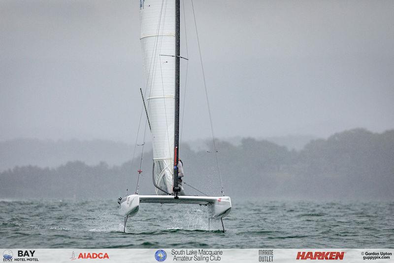 Australian A-Cat Nationals on Lake Macquarie Day 1 - Foiling gybes have yet to be successful in this class, but it won’t stop Adam Beattie giving it a go on his last downwind leg to his second bullet of the day photo copyright Gordon Upton taken at South Lake Macquarie Amateur Sailing Club and featuring the A Class Catamaran class