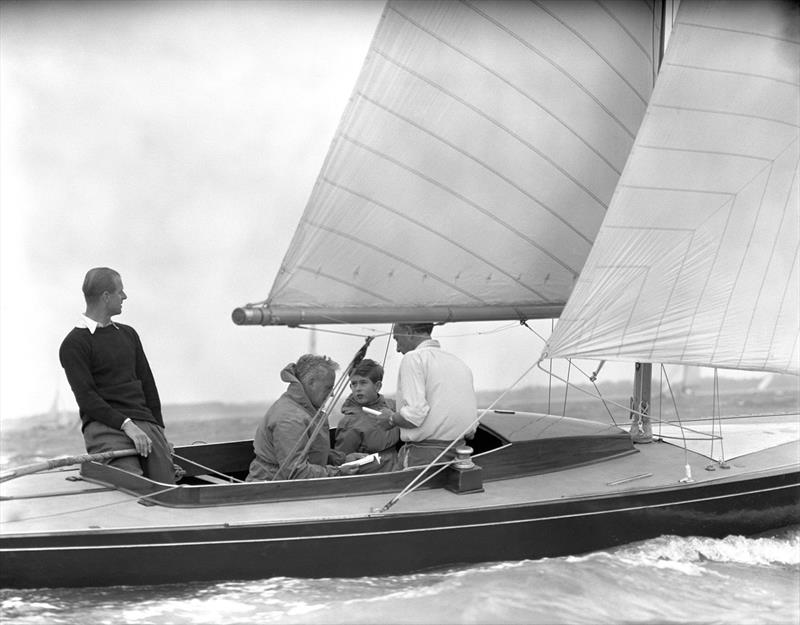Charles, Prince of Wales with his father the Duke of Edinburgh and crew members Uffa Fox, the Duke's Yachting adviser and Lieutenant-Commander Alistair Easton, Sailing Master of the yacht 
