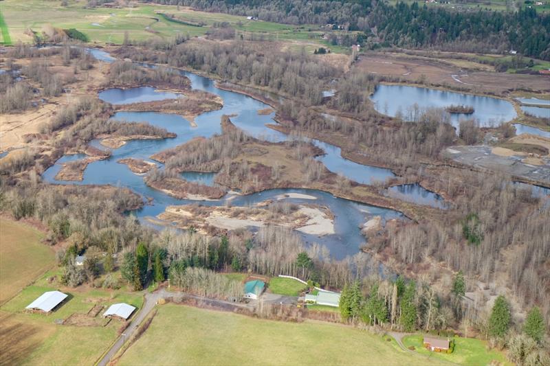 Aerial view of the Ridgefield Pits in the foreground on the East Fork Lewis River before restoration. The Daybreak Pits can also be seen and are located adjacent to the Ridgefield Pits. The project will focus on restoring the nine Ridgefield Pits photo copyright Lower Columbia Estuary Partnership taken at  and featuring the Environment class