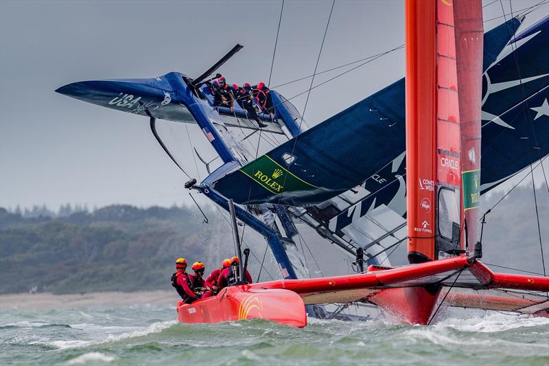 China SailGP Team sails past as the United States SailGP Team's F50 capsizes slowly after a turn during race one. Race Day. Event 4 Season 1 SailGP event in Cowes, Isle of Wight, England, United Kingdom photo copyright Ian Roman for SailGP taken at  and featuring the F50 class
