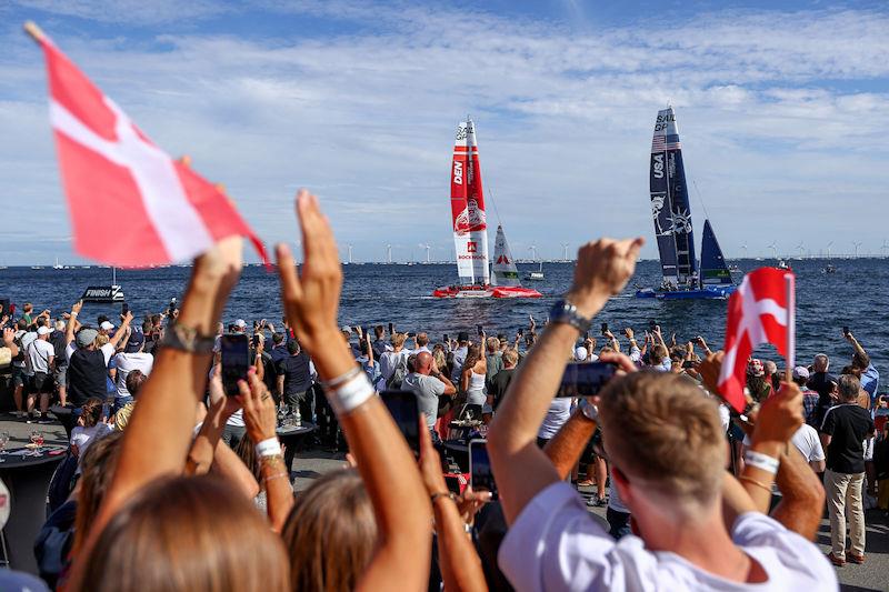 Fans in the Race Village cheer and wave flags as USA SailGP Team and Denmark SailGP Team presented by ROCKWOOL cross the finish line on Race Day 2 of the ROCKWOOL Denmark Sail Grand Prix in Copenhagen, Denmark - photo © Chloe Knott for SailGP