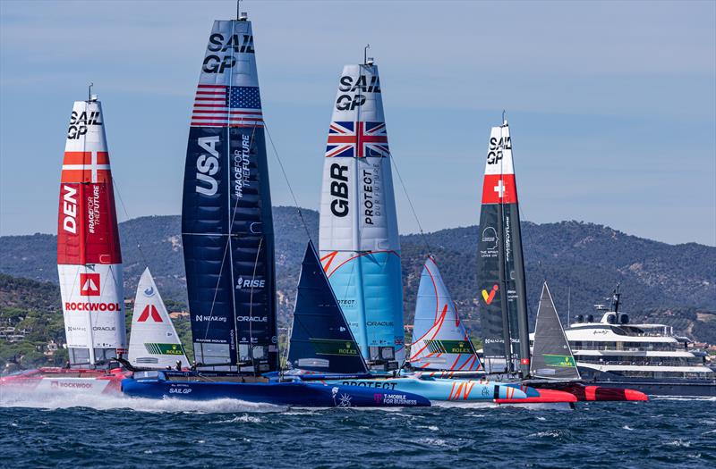 Denmark SailGP Team, USA SailGP Team, Great Britain SailGP Team, and Switzerland SailGP Team sail past the superyacht Here Comes The Sun on Race Day 1 of the Range Rover France Sail Grand Prix in Saint Tropez, photo copyright David Gray / SailGP taken at Société Nautique de Saint-Tropez and featuring the F50 class