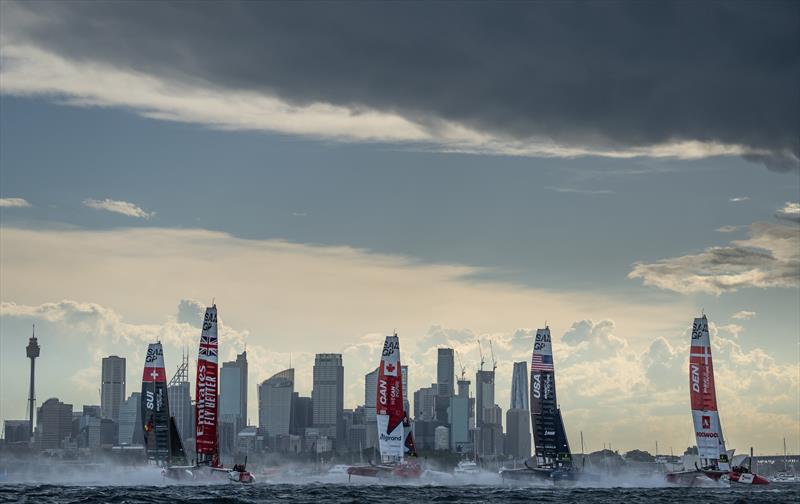 The fleet led by Denmark SailGP Team presented by ROCKWOOL ahead of USA SailGP Team, Canada SailGP Team Emirates Great Britain SailGP Team and Switzerland SailGP Team sail past the skyline on Race Day 1 of the KPMG Australia Sail Grand Prix in Sydney - photo © Bob Martin for SailGP