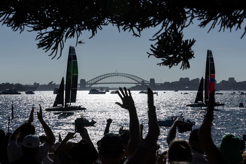 Silhouette of guests cheering as Australia SailGP Team and ROCKWOOL Denmark SailGP Team sail past Genesis Island with Sydney Harbour Bridge in the distance on Race Day 2 of the KPMG Australia Sail Grand Prix in Sydney, Australia photo copyright Patrick Hamilton for SailGP taken at  and featuring the F50 class