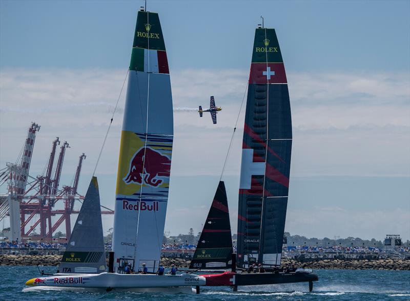 The Red Bull stunt aeroplane sales over the grandstand as the Red Bull Italy SailGP Team and Switzerland SailGP Team race past on Race Day 1 of the Oracle Perth Sail Grand Prix presented by KPMG in Perth, Australia photo copyright SailGP taken at  and featuring the F50 class