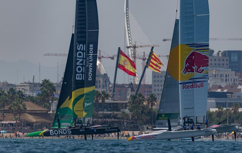 BONDS Flying Roos SailGP Team driven by Tom Slingsby ahead of Red Bull Italy SailGP Team driven by Phil Robertson as they sail past the shoreline on Race Day 1 of the Spain Sail Grand Prix in Valencia, Spain - photo © Samo Vidic for SailGP