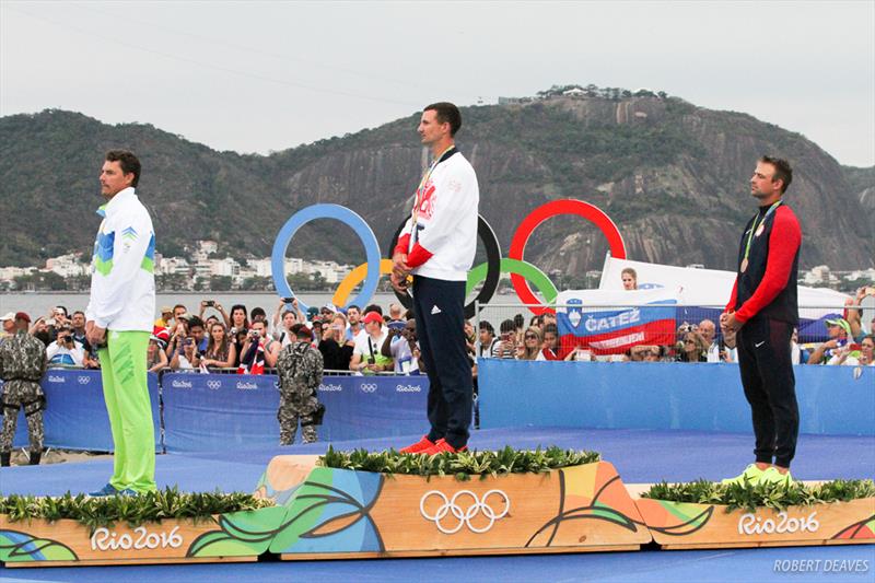 Flag raising in the Finn class medal ceremony at the Rio 2016 Olympic Sailing Competition photo copyright Robert Deaves taken at  and featuring the Finn class