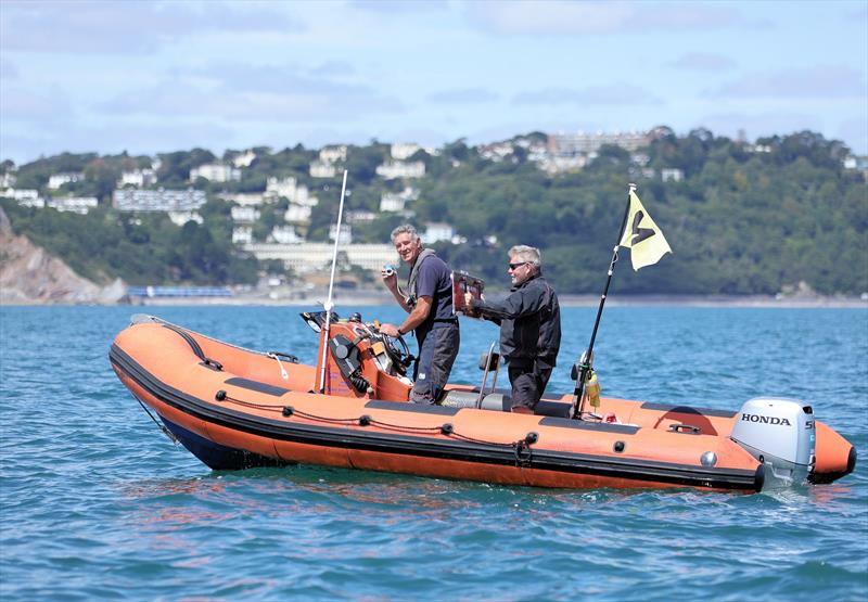 Nick Ripley drives a support RIB, while also sounding a change of course horn, on Day 2 of the 2026 Fireball World Championship at the Royal Torbay Yacht Club - photo © Mark Jardine