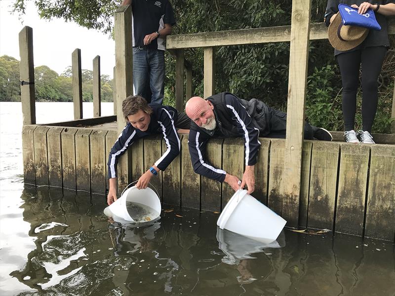 Two leaning down to stock: Two members of Marlo Angling Club stocking - photo © Sarah Hetherington