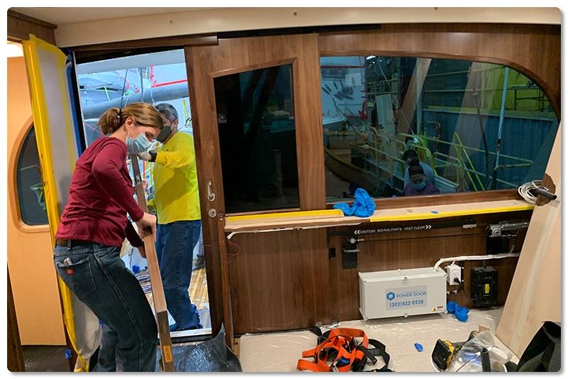 Interior Installer Ann Marie Kavanagh and Interior Trim Leadman Guido Monroy carry a stateroom door into the salon of a Viking 68 on Line 2 photo copyright Viking Yachts taken at  and featuring the Fishing boat class
