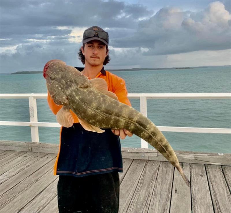 Lukas with a solid flathead from the Urangan pier. It can be awesome fun sight casting to these fish with live herring or pike as they make their way up onto the flat - photo © Fisho's Tackle World