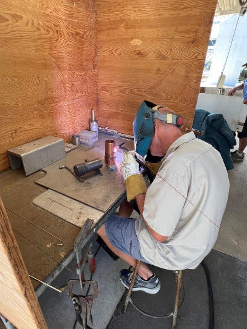 Hull #9 - Bill welding engine raw water plumbing - photo © Michael Rybovich & Sons