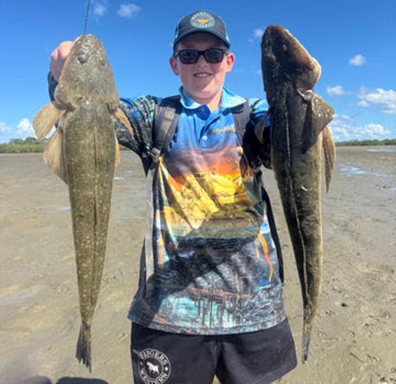 Reuben Barnett with a brace of the sort of flatties you can catch fishing our flats and creek mouths right now - photo © Fisho's Tackle World
