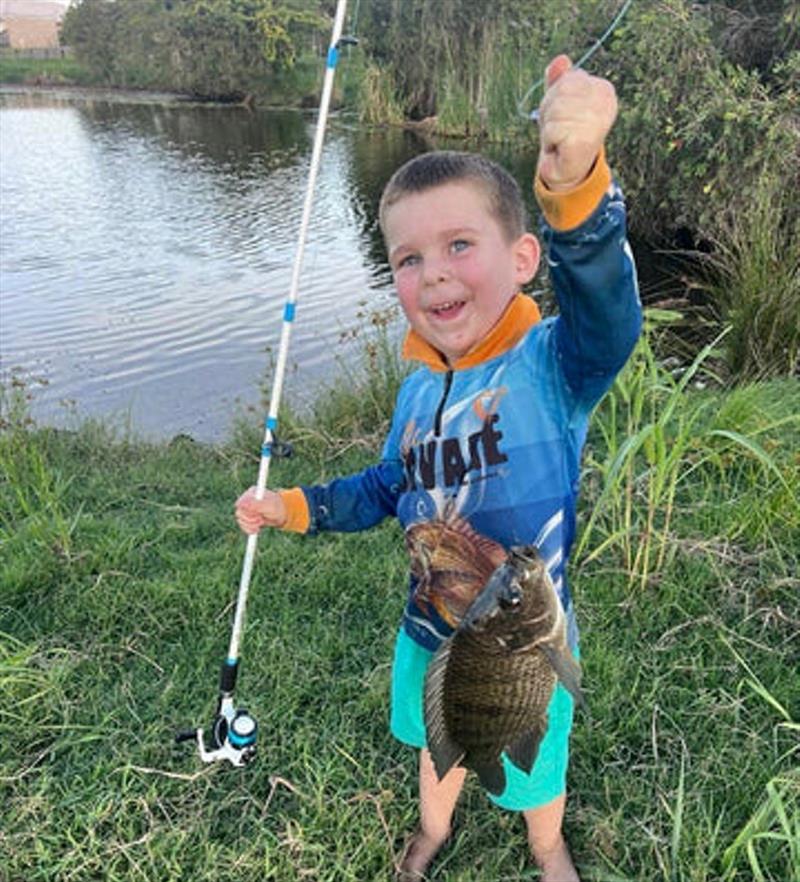 Eddie with a tilapia he caught from his backyard pre-flooding. There is thousands and thousands of these pests at large now - photo © Fisho's Tackle World