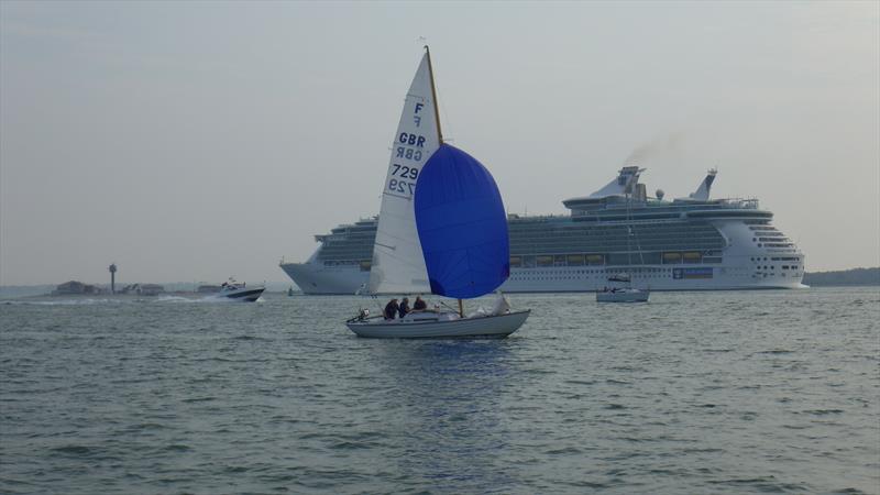 Nick Ingram's Folkboat Otter passing by Independence of the Seas during the Hamble Scramble photo copyright Alastair Beeton taken at Lymington Town Sailing Club and featuring the Folkboat class