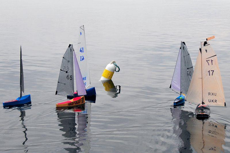 Whole fleet arrives at the first mark together - Footy class Videlo Globe at Frensham Pond photo copyright Roger Stollery taken at Frensham Pond Sailing Club and featuring the Footy class