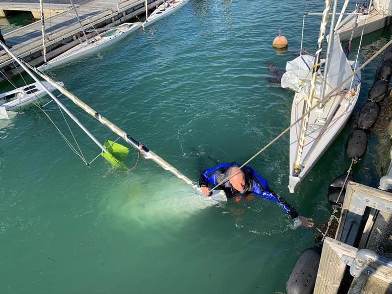 Olly Laughton-Scott swimming after his boat during buoyancy testing ahead of the Illusion Trafalgar Trophy at Bembridge photo copyright BSC taken at Bembridge Sailing Club and featuring the Illusion class