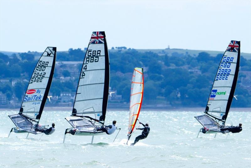 3 Moths and a windsurfer at Stokes Bay photo copyright Lorraine Budgen taken at Stokes Bay Sailing Club and featuring the International Moth class