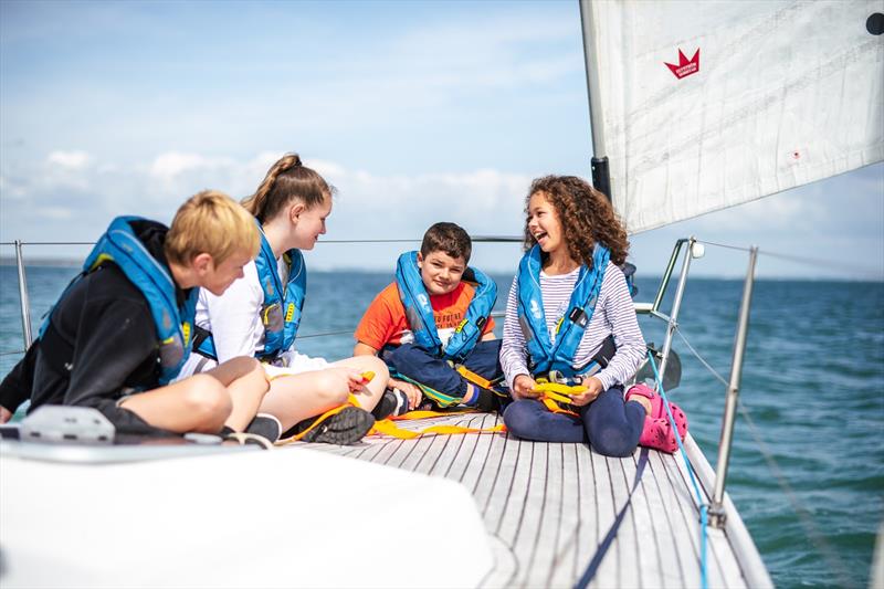 Young people sitting on a yacht on a trip from Cowes photo copyright Martin Allen Photography taken at  and featuring the IRC class