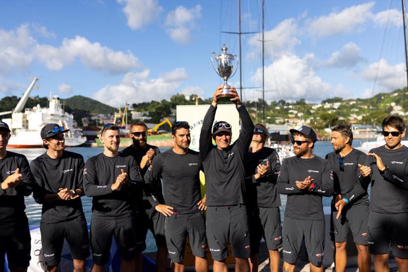 Skipper Grzegorz Baranowski proudly lifts the International Maxi Association Transatlantic Trophy for Monohull Line Honours - photo © Arthur Daniel / RORC