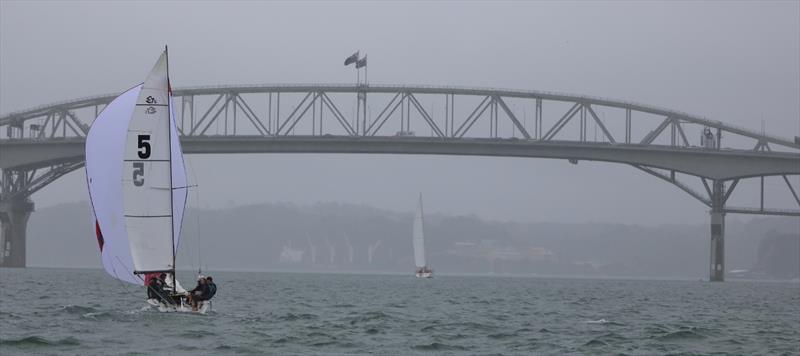 Frankie Dair and a gloomy outlook through the Harbour Bridge on day 2 of the 2018 Nespresso Youth International Match Racing Cup photo copyright Andrew Delves taken at Royal New Zealand Yacht Squadron and featuring the Match Racing class