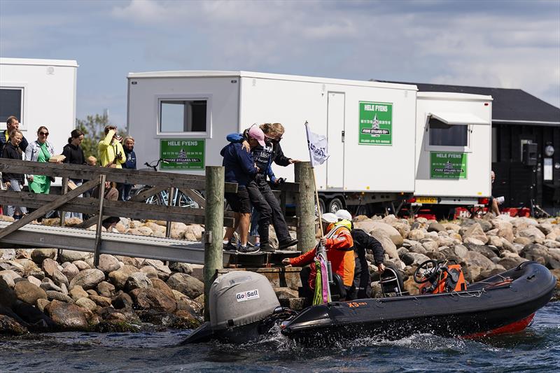 Liz Baylis and a volunteer assist Anna Östling getting back onto a RIB to re-start only moments after her injury on day 3 of the 2023 Women's Match Racing World Championship - powered by Bunker One photo copyright Mick Anderson taken at Middelfart Sailing Club and featuring the Match Racing class