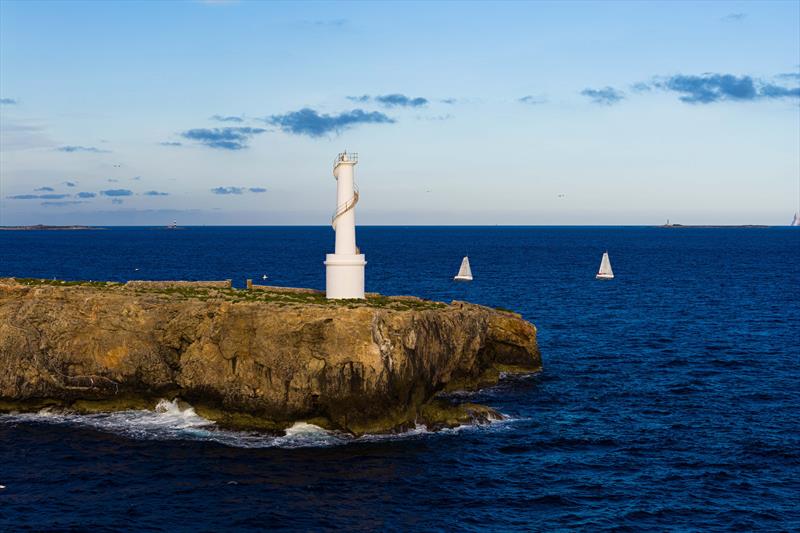 The Mini 6.50 fleet sailing past Ibiza at sunrise in La Larga 2026 photo copyright Ugo Fonollá/Sandberg PalmaVela taken at Real Club Náutico de Palma and featuring the Mini Transat class