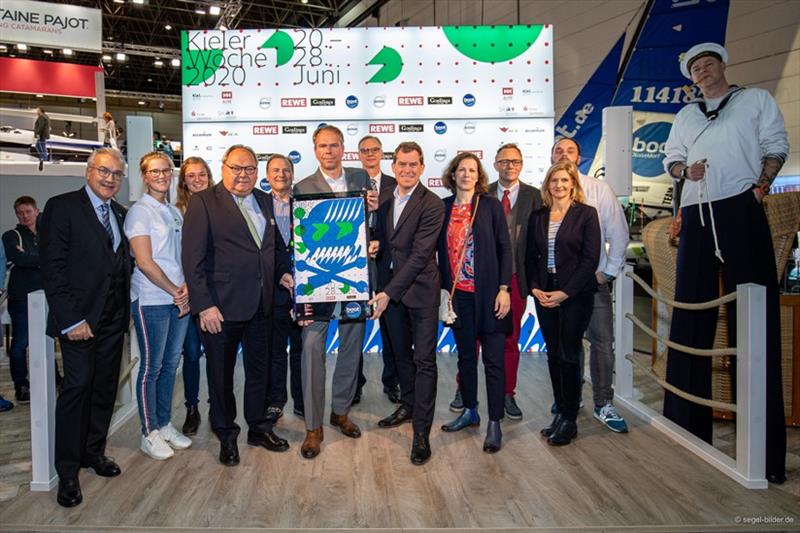 Head of OrganizationKiel Week Regattas Dirk Ramhorst (center) and Kiel's mayor Dr. Ulf Kämpfer present the currentKiel Week poster every year at boot. - photo © www.segel-bilder.de