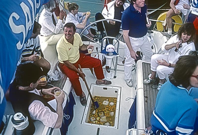 Bob Fisher hosting a party aboard Barracuda of Tarrant serving (sponsored?) rum punch from the liferaft well. - photo © Guy Gurney