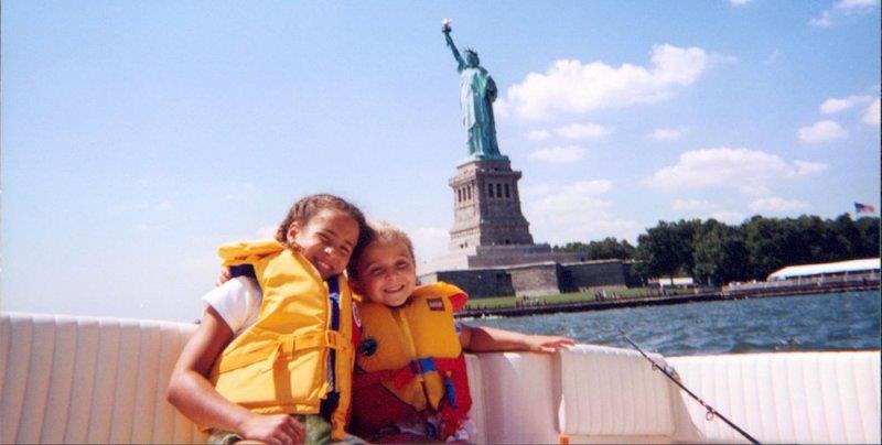 Kelsey and Taylor have been sightseeing by boat as they pose with Lady Liberty in the background photo copyright Grady-White taken at 
