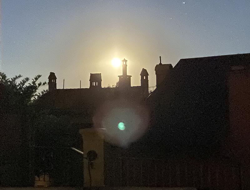 Moon rises over the town of Grandson on lake Neufchatel, Switzerland photo copyright John Curnow taken at Cercle de la Voile de Grandson