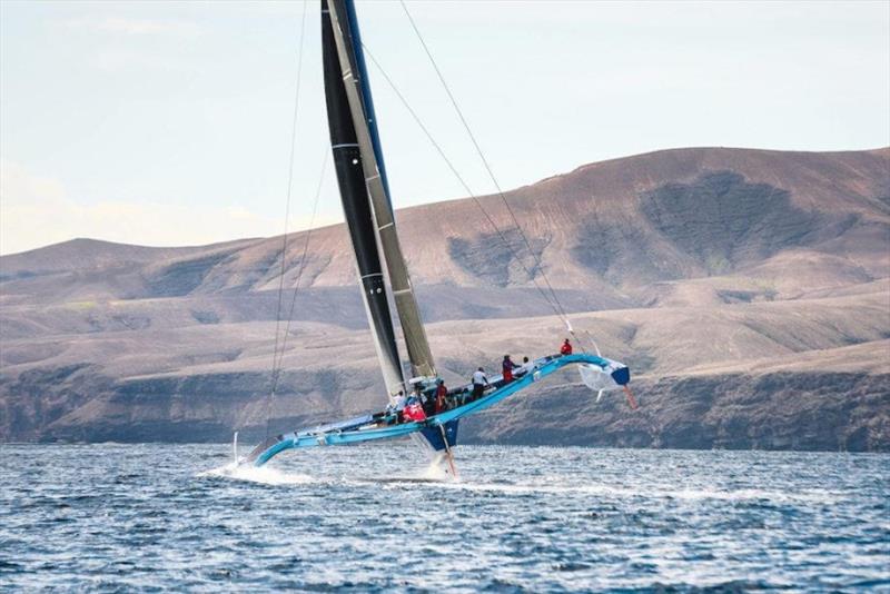 A dramatic backdrop as PowerPlay heads off for the spice island of Grenada after the start of the RORC Transatlantic Race off Puerto Calero Marina, Lanzarote photo copyright James Mitchell / RORC taken at Royal Ocean Racing Club and featuring the MOD70 class