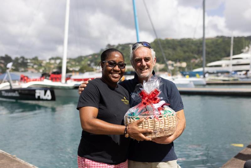 Loick Peyron on behalf of team Zoulou is presented with a beautiful basket of local produce from Grenada after completing the race - RORC Transatlantic Race photo copyright Arthur Daniel / RORC taken at Royal Ocean Racing Club and featuring the MOD70 class