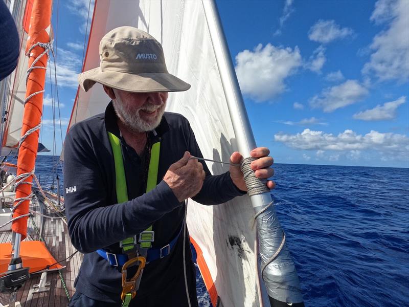 Skipper Mark Sinclair, AKA Captain Coconut, attempting to fix their furler with some duct tape and string - photo © Explorer / OGR2023